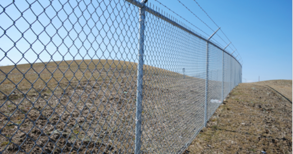 Chain link fence with barbed wire top in construction zone